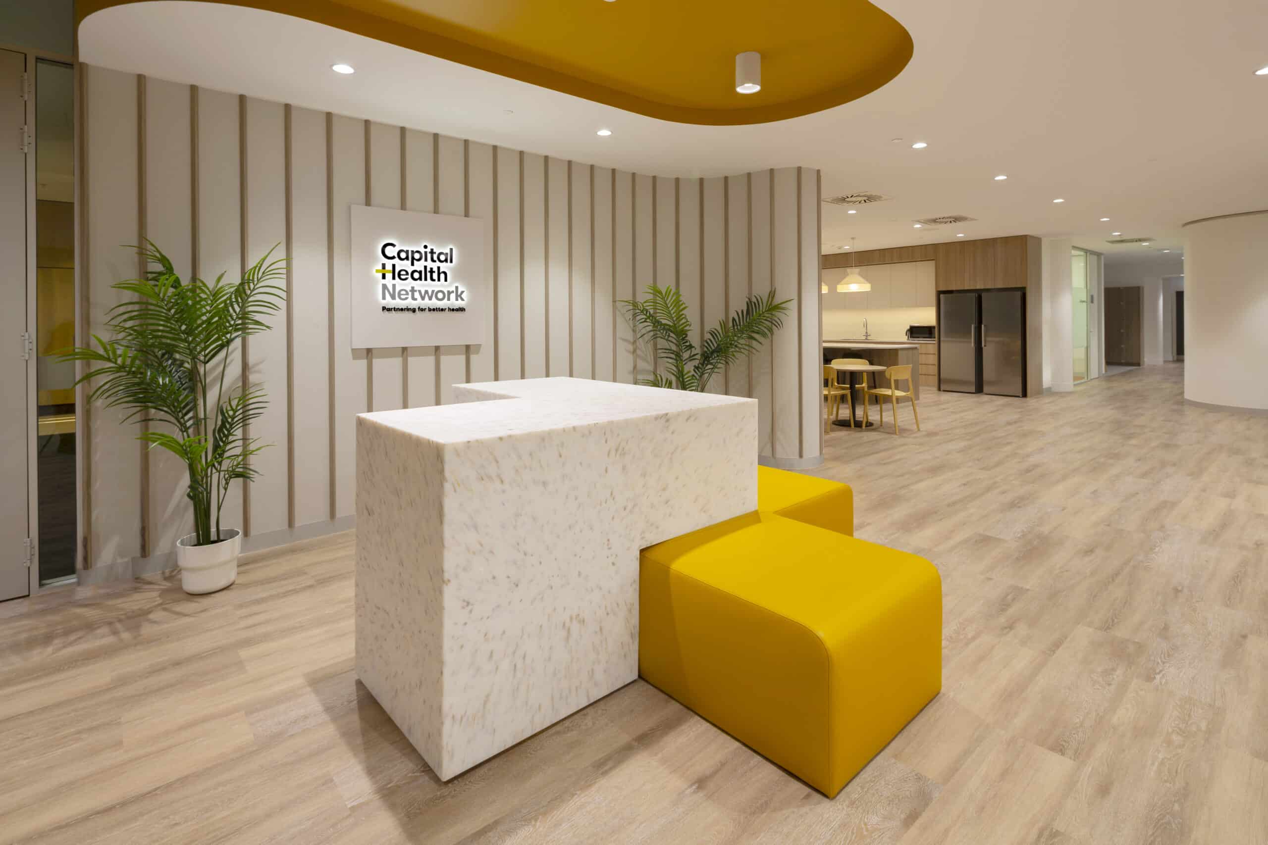 Contemporary office reception area with a sleek front desk, comfortable seating, and modern design elements, creating a welcoming atmosphere.